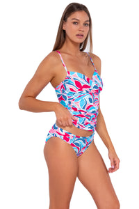 Side pose #1 of Daria wearing Sunsets Making Waves Simone Tankini Top lifted to show matching Audra Hipster bikini bottom