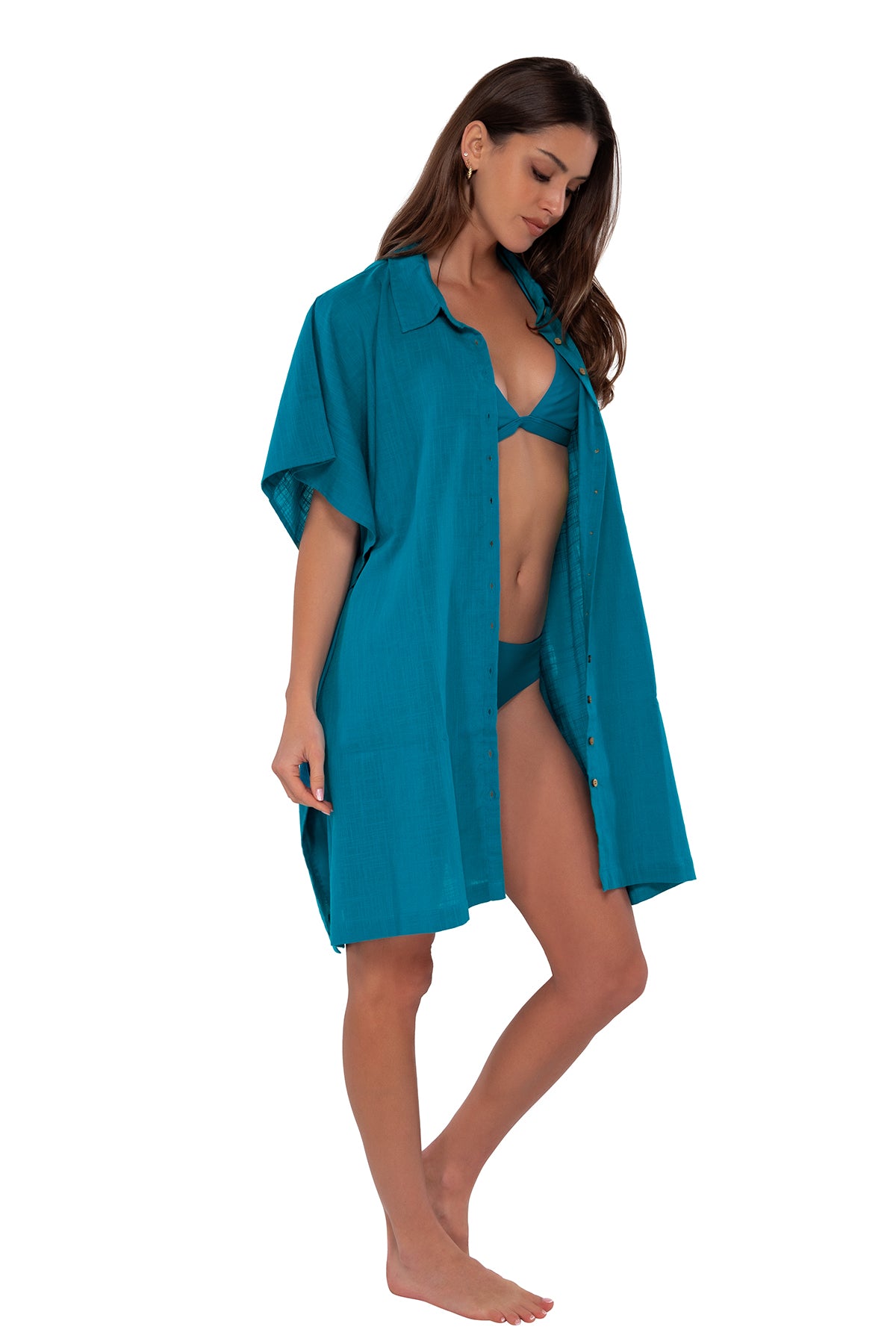 Side pose #1 of Gigi wearing Sunsets Avalon Teal Shore Thing Tunic as an open shirt