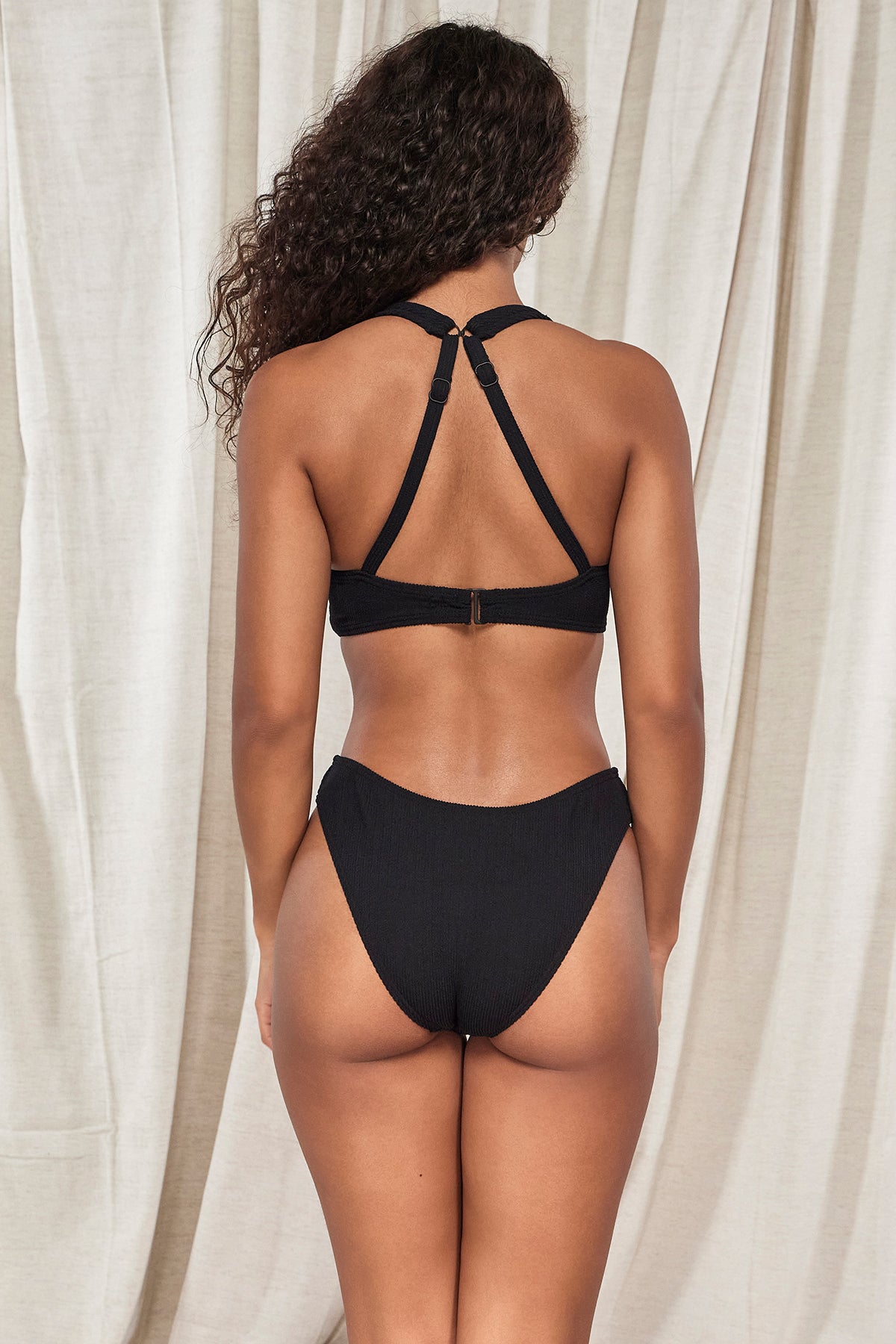 Back pose #1 of Jasmine wearing Pacifica Black Sandy Scoop Bottom paired with matching Mirabella Bikini Top