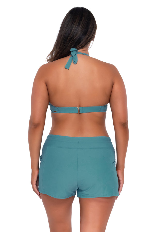 Back pose #1 of Nicky wearing Sunsets Escape Ocean Laguna Swim Short with matching Muse Halter bikini top