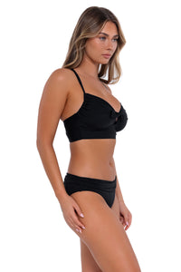 Side pose #1 of Taylor wearing Sunsets Black Colette Bralette Top with matching Unforgettable Bottom bikini