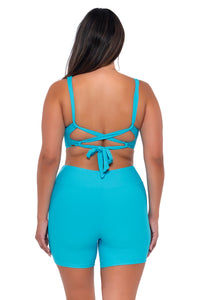 Back pose #1 of Nicky wearing Sunsets Blue Bliss Elsie Top with matching Bayside Bike Short swim bottom