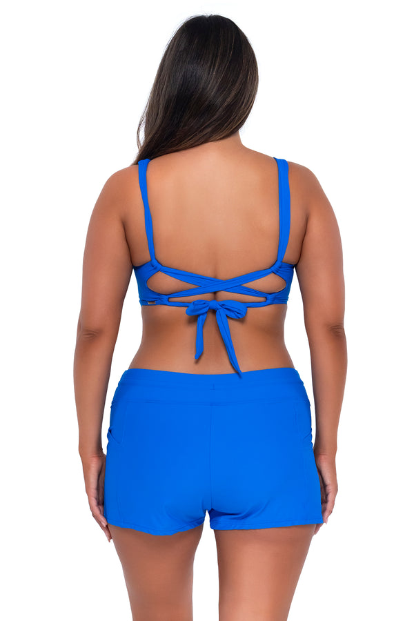 Back pose #1 of Nicky wearing Sunsets Escape Electric Blue Laguna Swim Short with matching Elsie Top underwire bikini