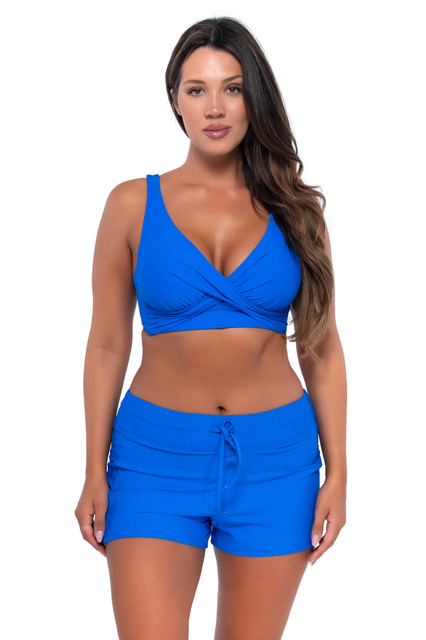 Front pose #1 of Nicky wearing Sunsets Escape Electric Blue Laguna Swim Short with matching Elsie Top underwire bikini
