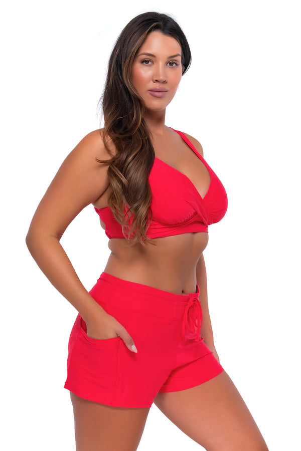 Side pose #2 of Nicky wearing Sunsets Escape Geranium Laguna Swim Short with matching Elsie Top underwire bikini