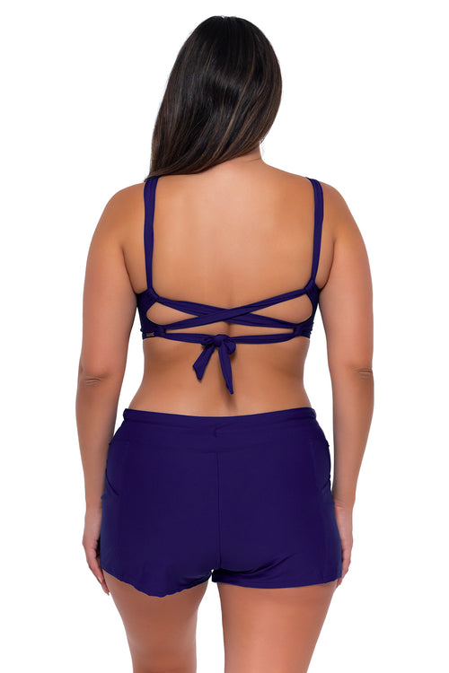 Back pose #1 of Nicky wearing Sunsets Escape Indigo Laguna Swim Short with matching Elsie Top underwire bikini