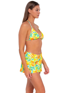 Side pose #1 of Daria wearing Sunsets Golden Tropics Sandbar Rib Sporty Swim Skirt with matching Laney Triangle bikini top