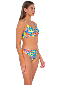 Side pose #1 of Daria wearing Sunsets Shoreline Petals Unforgettable Bottom with matching Lyla Bralette bikini top