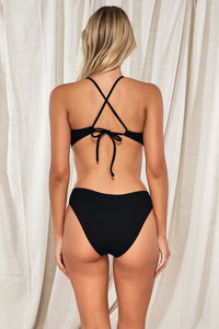 Back pose #1 of Jessica wearing Pacifica Black Indie Bralette Top paired with matching Penny Hipster Bikini Bottom