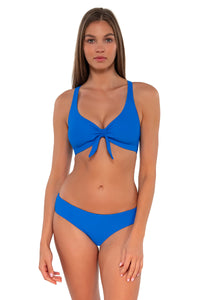 Front pose #1 of Daria wearing Sunsets Electric Blue Brandi Bralette Top showing bralette front tie with matching Alana Reversible Hipster bikini bottom