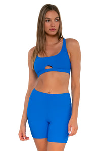 Front pose #1 of Daria wearing Sunsets Escape Electric Blue Bayside Bike Short with matching Brandi Bralette bikini top