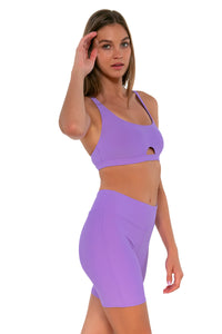 Side pose #1 of Daria wearing Sunsets Escape Passion Flower Bayside Bike Short with matching Brandi Bralette bikini top