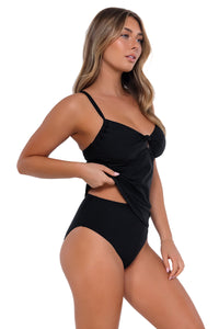 Side pose #1 of Taylor wearing Sunsets Black Maeve Tankini Top lifted up to show matching High Road Bottom bikini