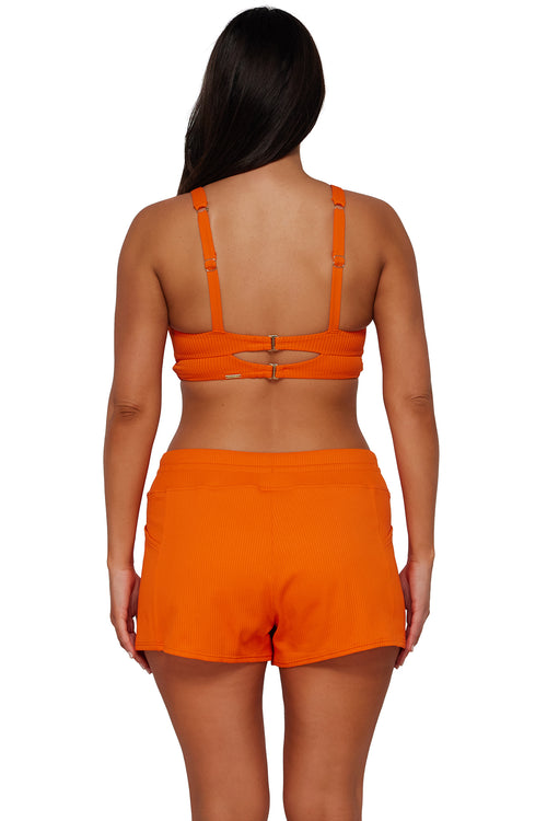 Back pose #1 of Nicki wearing Sunsets Escape Kumquat Sandbar Rib Laguna Swim Short paired with matching Bikini Top