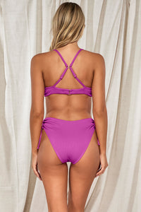 Back pose #1 of Jessica wearing Swim Systems Orchid Rio Rib Bonnie Top showing crossback straps paired with matching Malia High Waist Bottom