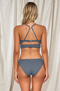 Back pose #1 of Jessica wearing Swim Systems Dusk Daisy Eyelet Kaia Top showing crossback straps paired with matching Chloe Bikini Bottom