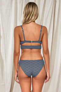 Back pose #1 of Jessica wearing Swim Systems Dusk Daisy Eyelet Chloe Bottom paired with matching Kaia Bikini Top