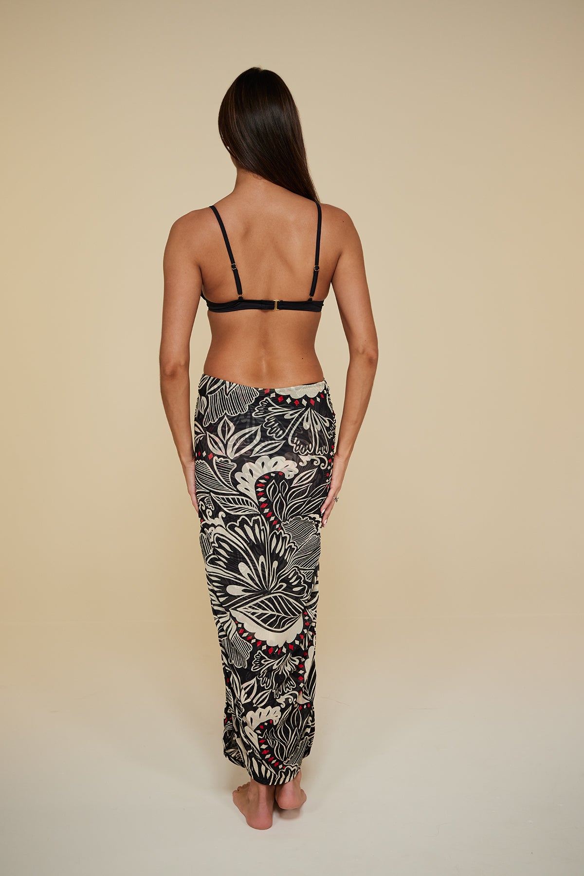 Back pose #1 of Jaida wearing B Swim  Miyajima Caspian Cover-Up as a skirt paired with Black Depth Meridian Underwire Top