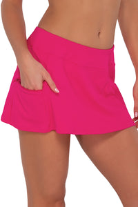 Side pose #1 of Gigi wearing Sunsets Begonia Sandbar Rib Sporty Swim Skirt with hand in pocket