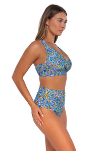 Side pose #1 of Taylor wearing Sunsets Pansy Fields Hannah High Waist Bottom with matching Elsie Top underwire bikini