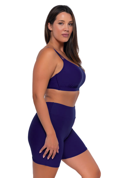 Side pose #1 of Nicky wearing Sunsets Escape Indigo Bayside Bike Short with matching Taylor Bralette bikini top
