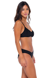 Side pose #1 of Chonzie wearing Swim Systems Black Bonnie Top with matching Chloe bikini bottom